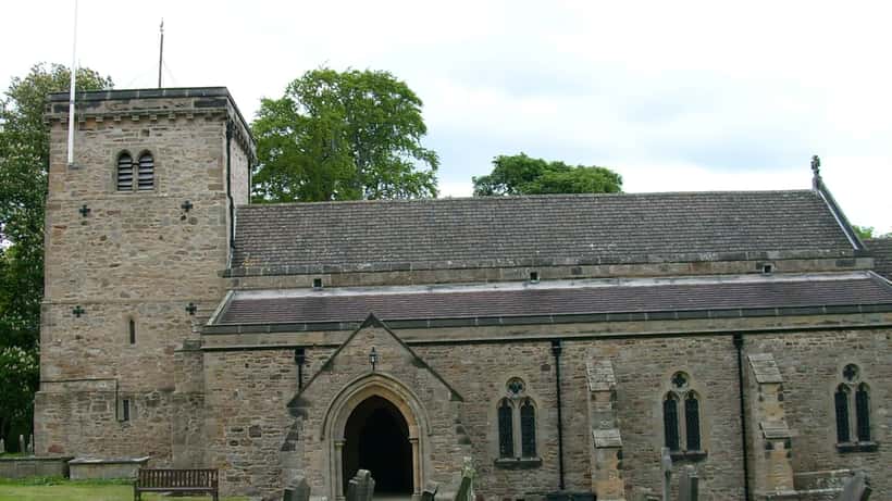 Historic English parish church with stone tower surrounded by countryside