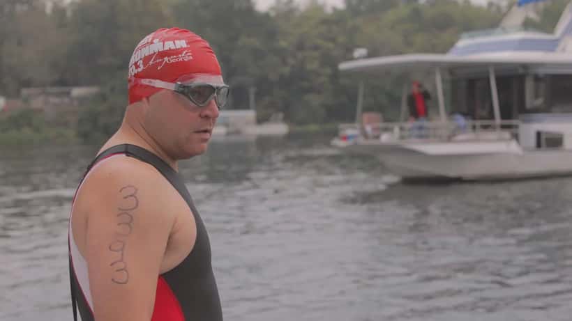 Athlète en combinaison de natation se préparant pour la phase de nage de l'épreuve Ironman