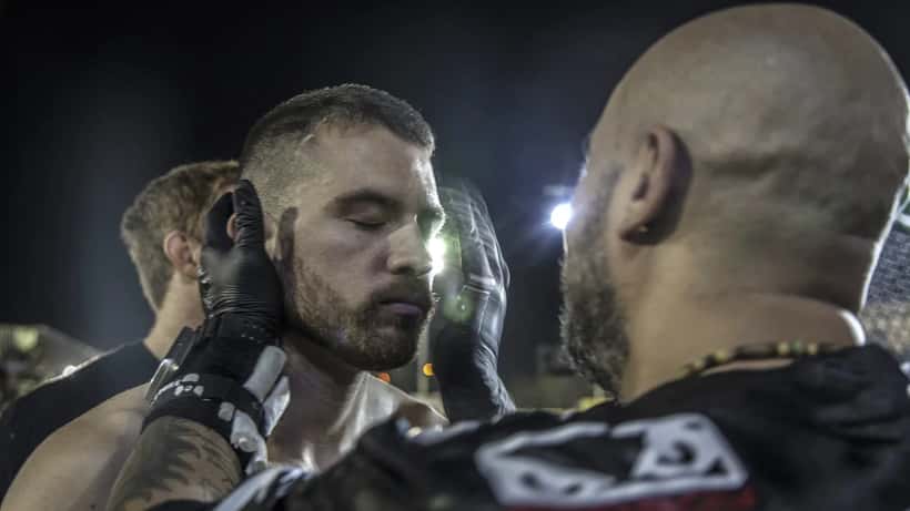 Combattants MMA lors d'un combat en cage sous les lumières de l'arène