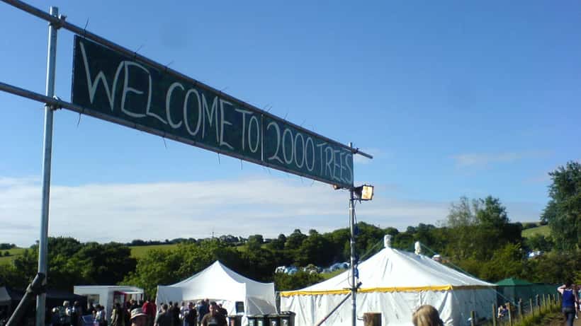 Entrance to 2000trees Festival with crowds at an outdoor music event in summer sunshine