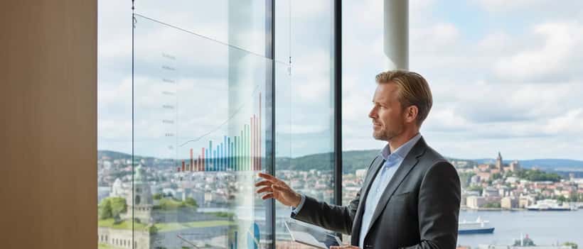 Norsk næringslivsperson ser på investeringsgrafer i Oslo-kontor