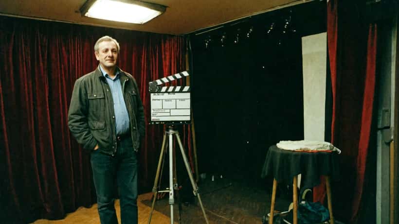 Schauspieler backstage in einem Wiener Theater mit Bühnenlichtern und Kostümständern