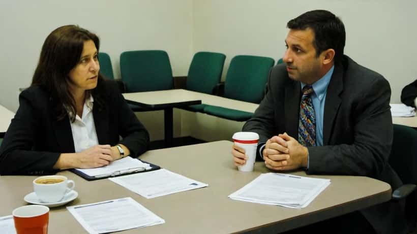 HR manager and union representative reviewing employment contract documents at a conference table