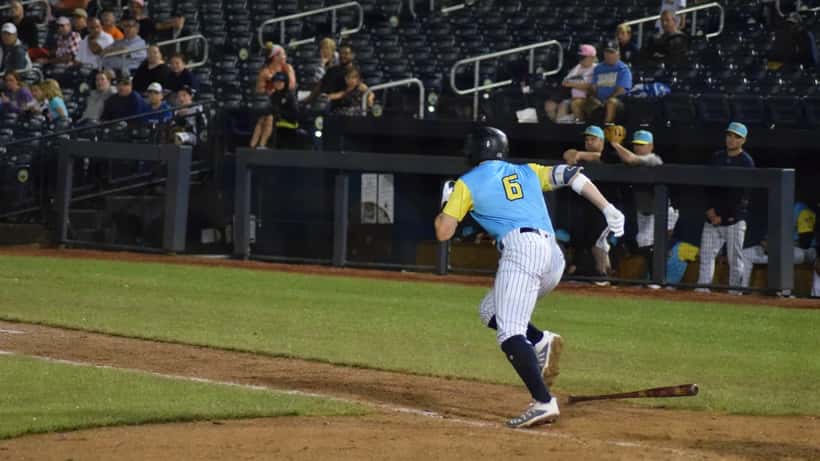 Minor league baseball shortstop throwing to first base during a game