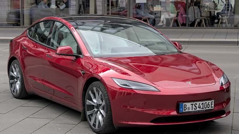 Tesla Model 3 eléctrico en exposición automovilística — crisis de concesionarios EV en EE.UU. 2026