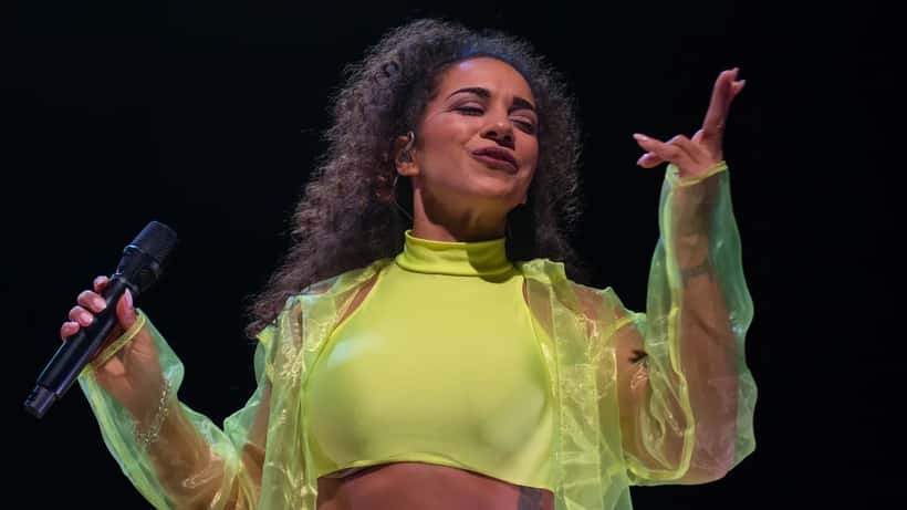 Nadja Benaissa sur scène lors d'un concert de No Angels en 2022, lumières colorées