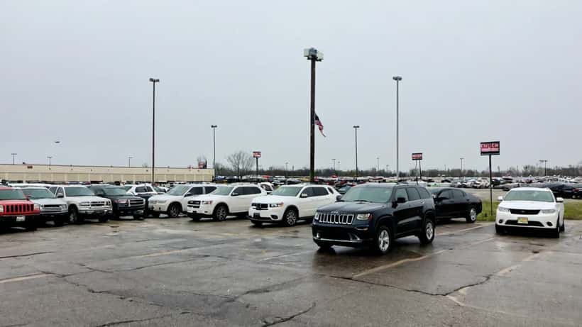 Concesionario de Jeep y Dodge vacío con vehículos sin vender bajo cielo nublado en Michigan