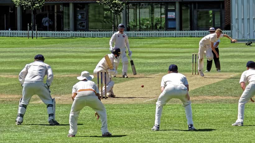 Cricket match at an English ground with white-clad players, representing legal sports betting for Canadian fans