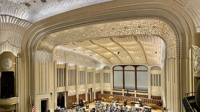 Klassieke concertzaal met rode stoelen en groot podium