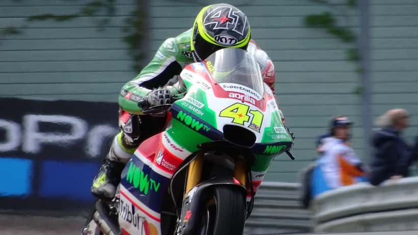 Motos MotoGP en pleine course sur circuit, pilotes en combinaison, vue aérienne de virage