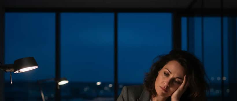 Femme épuisée à son bureau à 3h30 du matin, illustrant le burnout professionnel