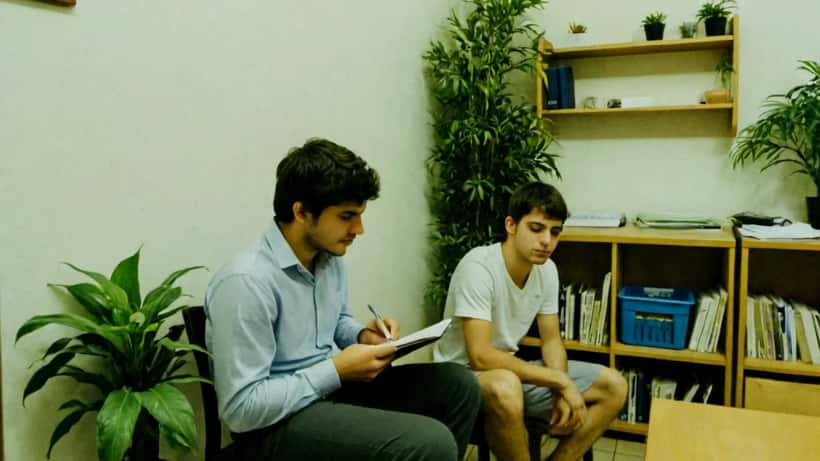 Jovem em consulta psicológica em consultório em São Paulo, psicólogo ouvindo atentamente