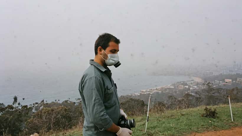 Health worker checking air quality with respirator mask during volcanic ash event in Australia