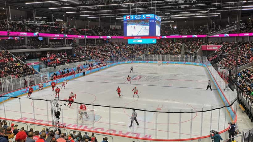 Joueurs de hockey junior canadien en action sur la glace lors des olympiades d'hiver de la jeunesse