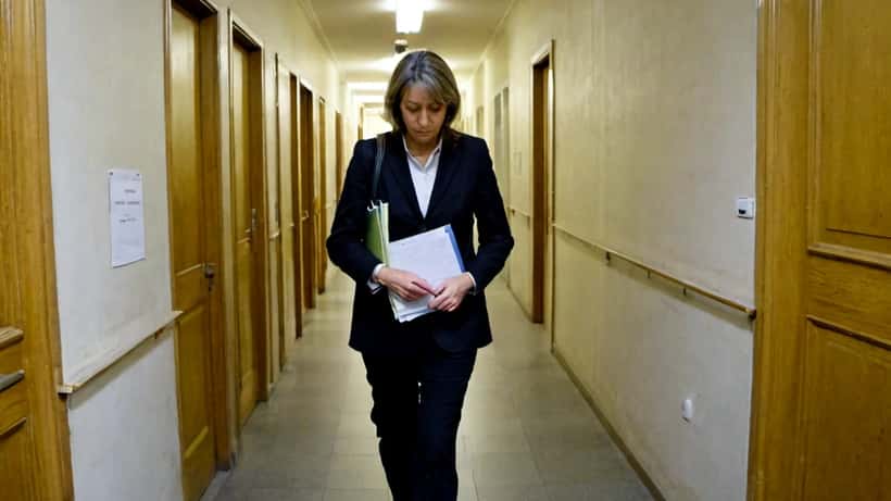 Avocate portant des dossiers dans le couloir d'un tribunal parisien