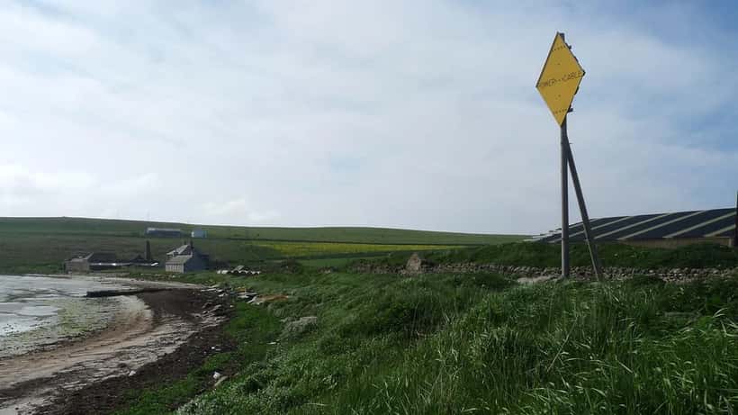 Skilt om undersøisk strømkabel ved kystlinjen — illustrerer risikoen for kabelsabotage i Østersøen