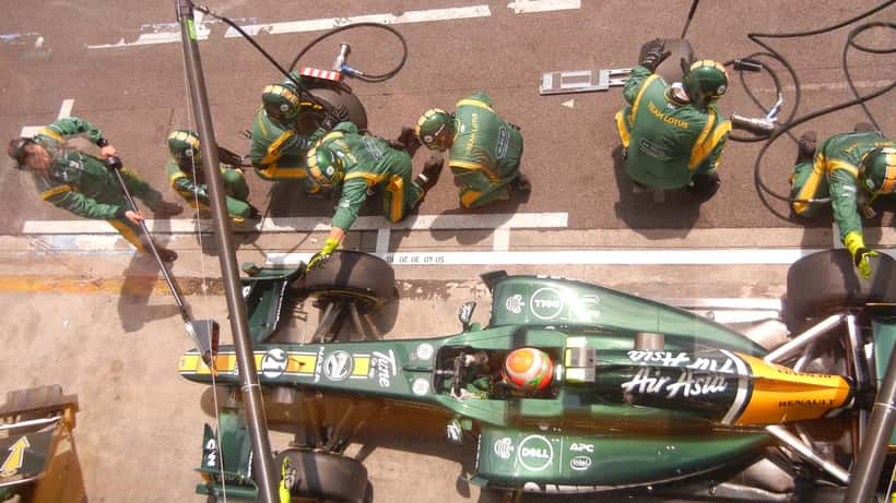 Mecánicos realizando un pitstop en el Gran Premio de Brasil de Fórmula 1, con ingenieros y tecnología de telemetría en el fondo