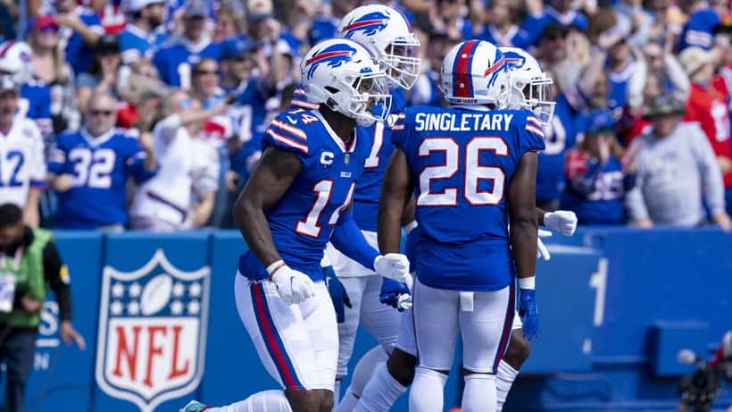 Jugadores de fútbol americano en acción durante partido de la NFL, corredor avanzando con el balón