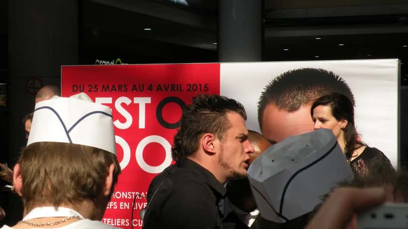 Norbert Tarayre chef cuisinant en démonstration culinaire, tablier blanc