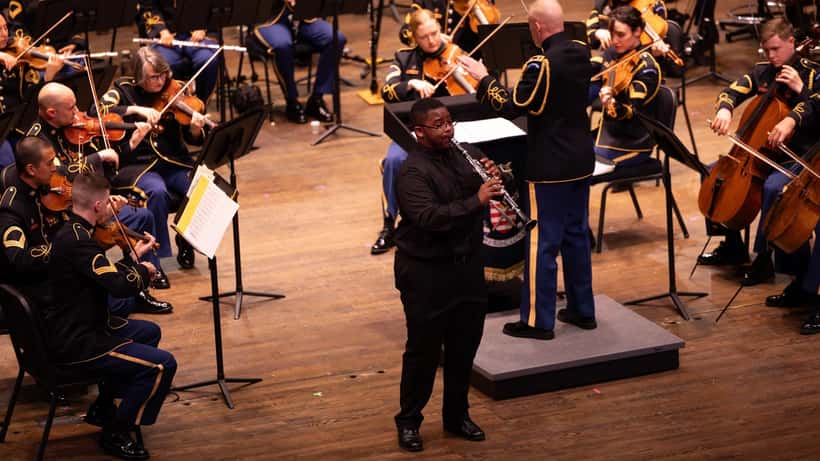 Orchester-Konzert mit Dirigent und Violinisten auf der Bühne