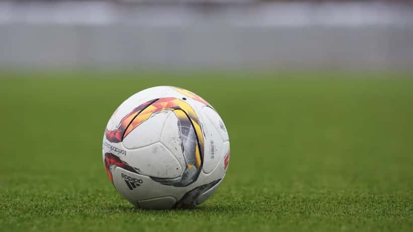 Adidas soccer ball sitting on a green grass football pitch