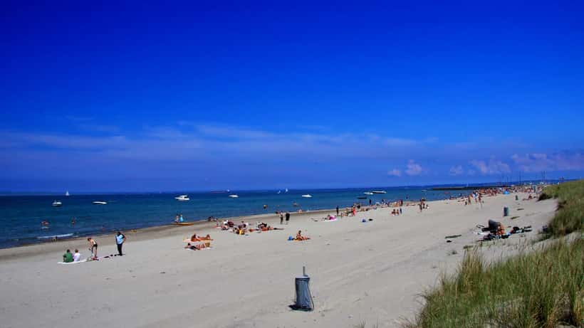 Hornbæk strand på en sommerdag med baders og blåt hav i baggrunden