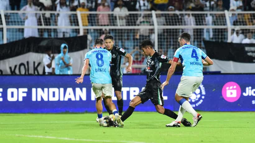 ISL footballer in action on the pitch during an Indian Super League match with stadium crowd in background