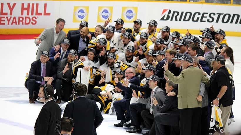 Pittsburgh Penguins players celebrating with the NHL Stanley Cup trophy