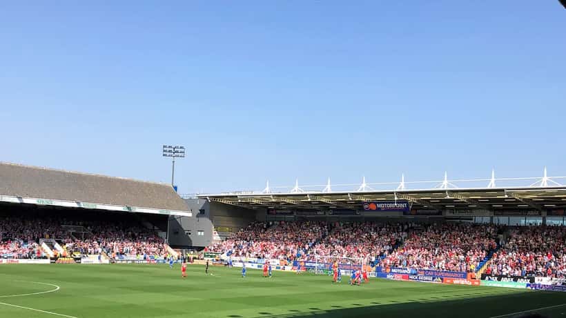 English football fans packed into a stadium cheering during a match