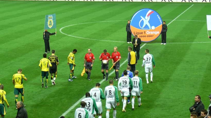 Avocate spécialisée en droit du sport examine des documents de transfert footballistique dans un cabinet parisien