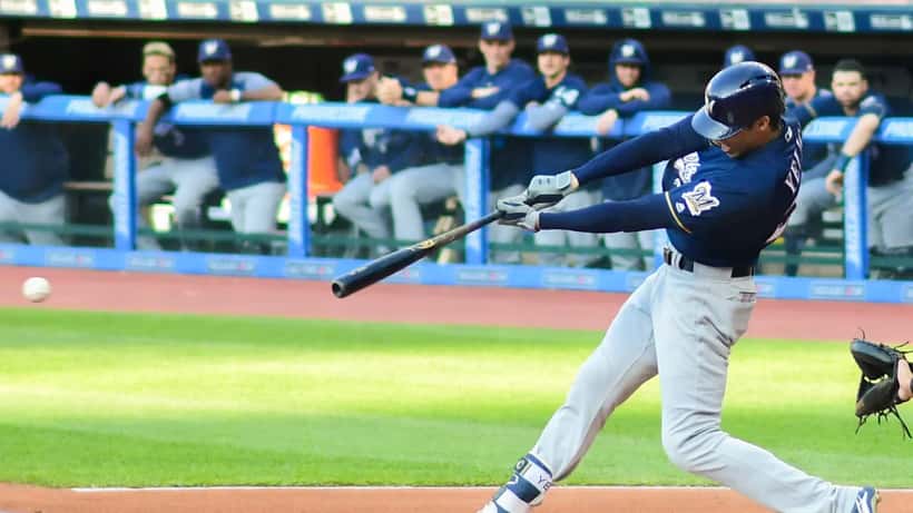 Milwaukee Brewers players competing in a game at American Family Field, stadium crowd in background