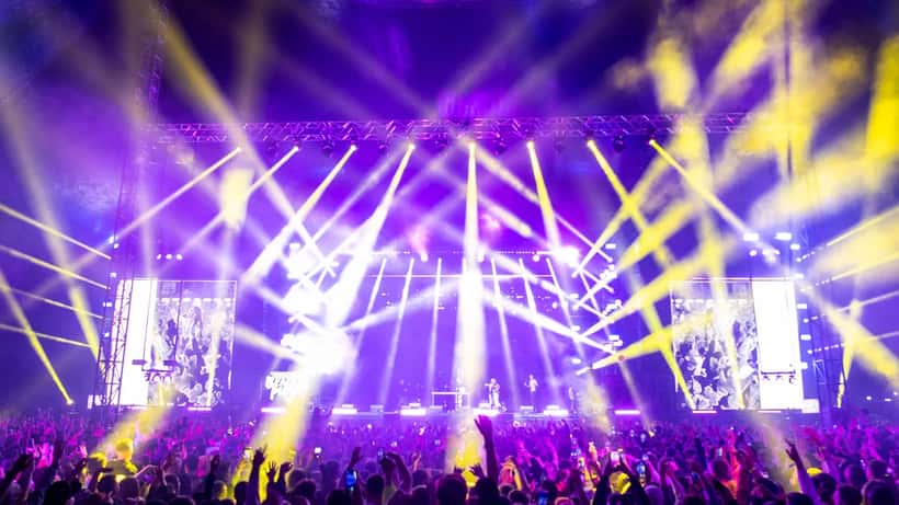 Folla a un concerto dal vivo con luci colorate sul palco