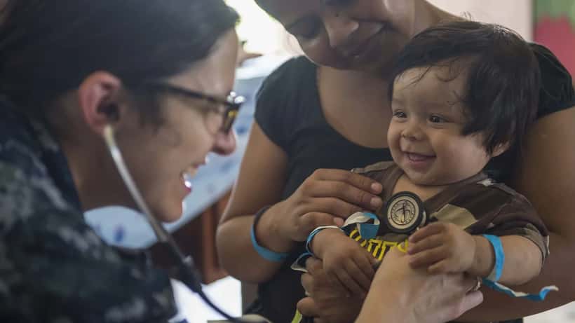 Physician examining a child during a medical consultation, representing medical child abuse recognition