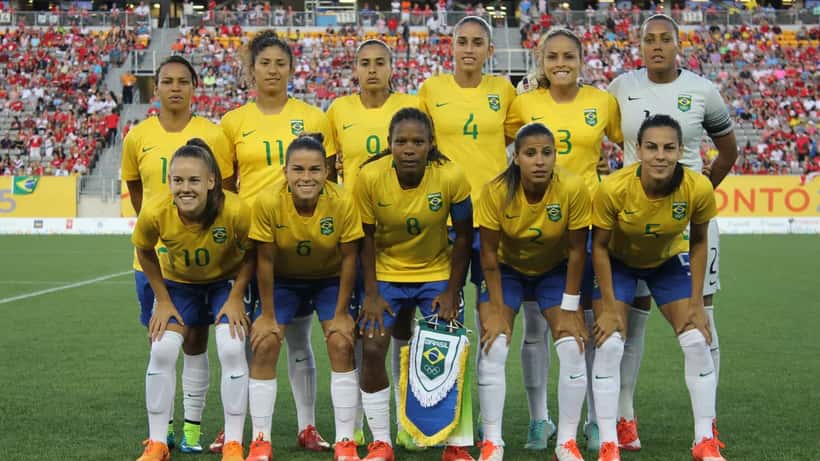 Jogadoras de futebol feminino do Brasil e Canadá disputando bola nos Jogos Pan-Americanos