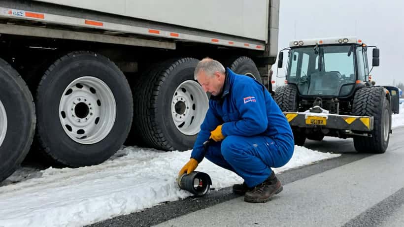 Mekaniker kontrollerer dekkdybde på et 60-tonns vogntog på en norsk vei om vinteren