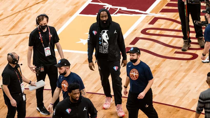 James Harden playing basketball in an NBA game, dribbling past defenders