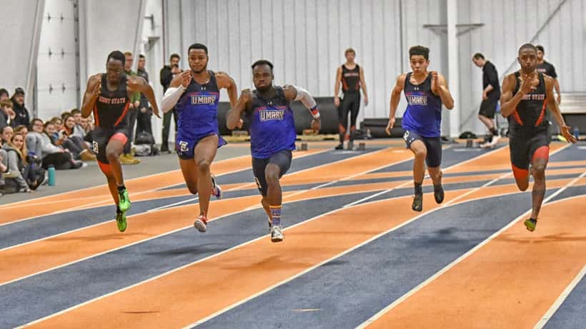 Male athlete sprinting on a university athletics track during a competitive sprint event