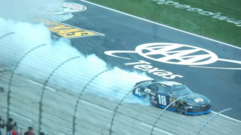 Kyle Busch célébrant une victoire NASCAR, champion emblématique du sport automobile américain
