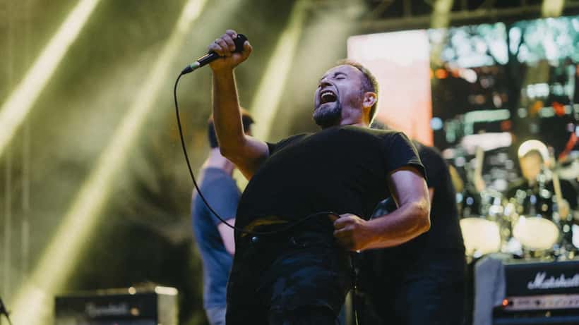 Chanteur en concert sur scène lors d'un festival en soirée, lumières vives