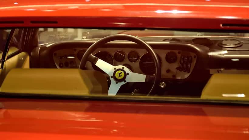 Roter Ferrari Sportwagen auf einer Automesse, Symbol für Luxusgüter-Investment