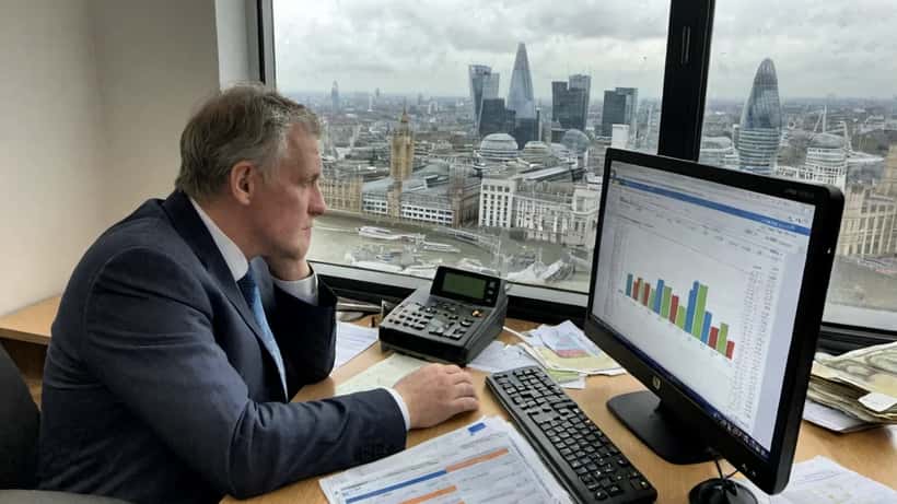 Financial analyst reviewing declining GDP chart in London office