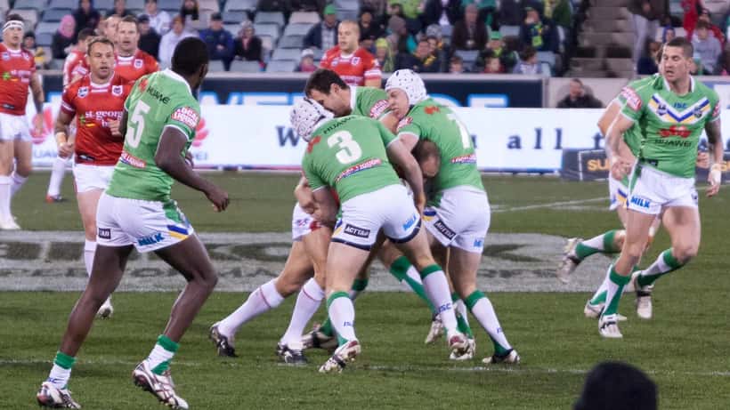 Canberra Raiders NRL players in a tackle during a match