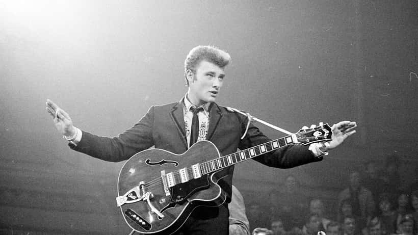 Performance de Johnny Hallyday sur scène en 1963, photo de concert en noir et blanc