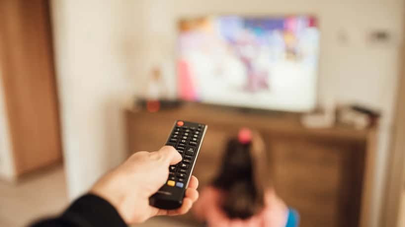 Perhe katsoo TV:tä kaukosäätimellä — Elisan kanavakatkos kuluttajan oikeudet