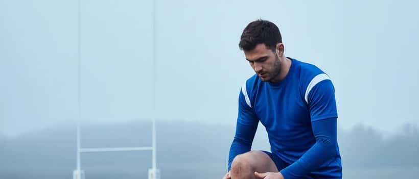 Jeune rugbyman tapant son genou avant l'entraînement à Bordeaux