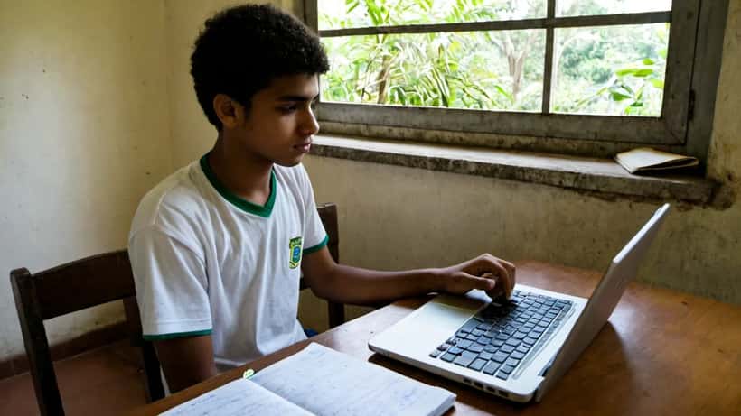 Estudante brasileiro preenchendo formulário de isenção ENEM 2026 no computador em casa