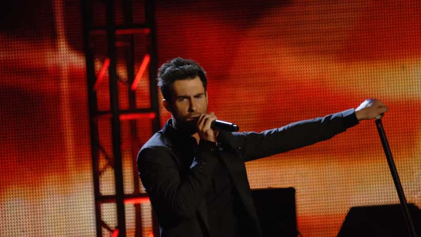 Adam Levine cantando no palco durante show do Maroon 5, técnico vencedor do The Voice
