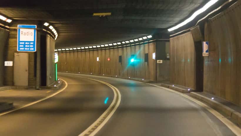 Intérieur du tunnel routier du Saint-Gothard avec voitures en circulation, axe de transit majeur des Alpes suisses