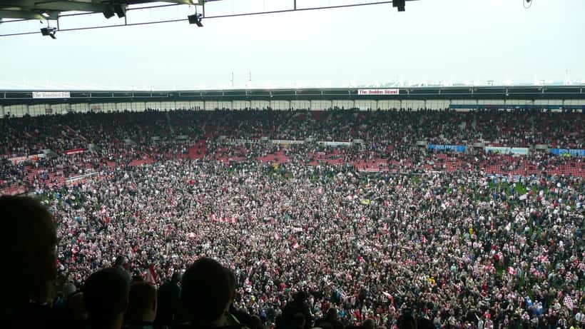 Football players celebrating a Premier League promotion at a packed stadium