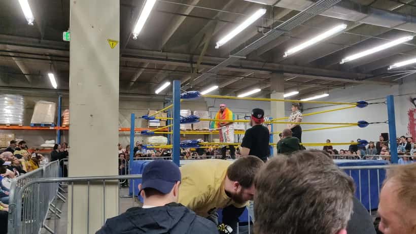 Professional wrestlers competing inside a wrestling ring at a local event, documentary style photography